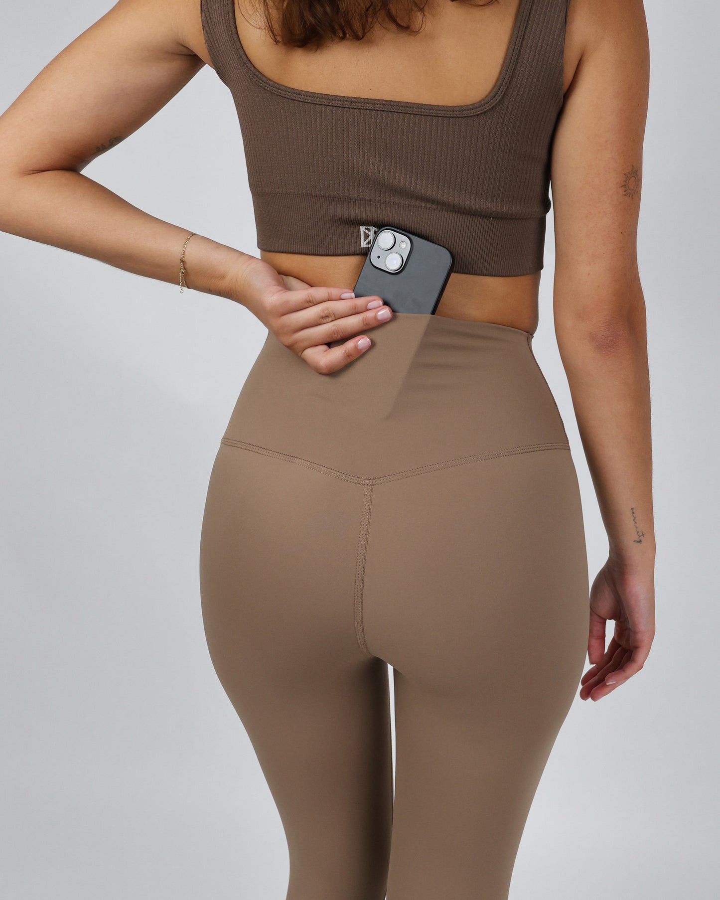 Model trägt die ACTIVE Leggings von DRILLS mit Tasche in Taupe