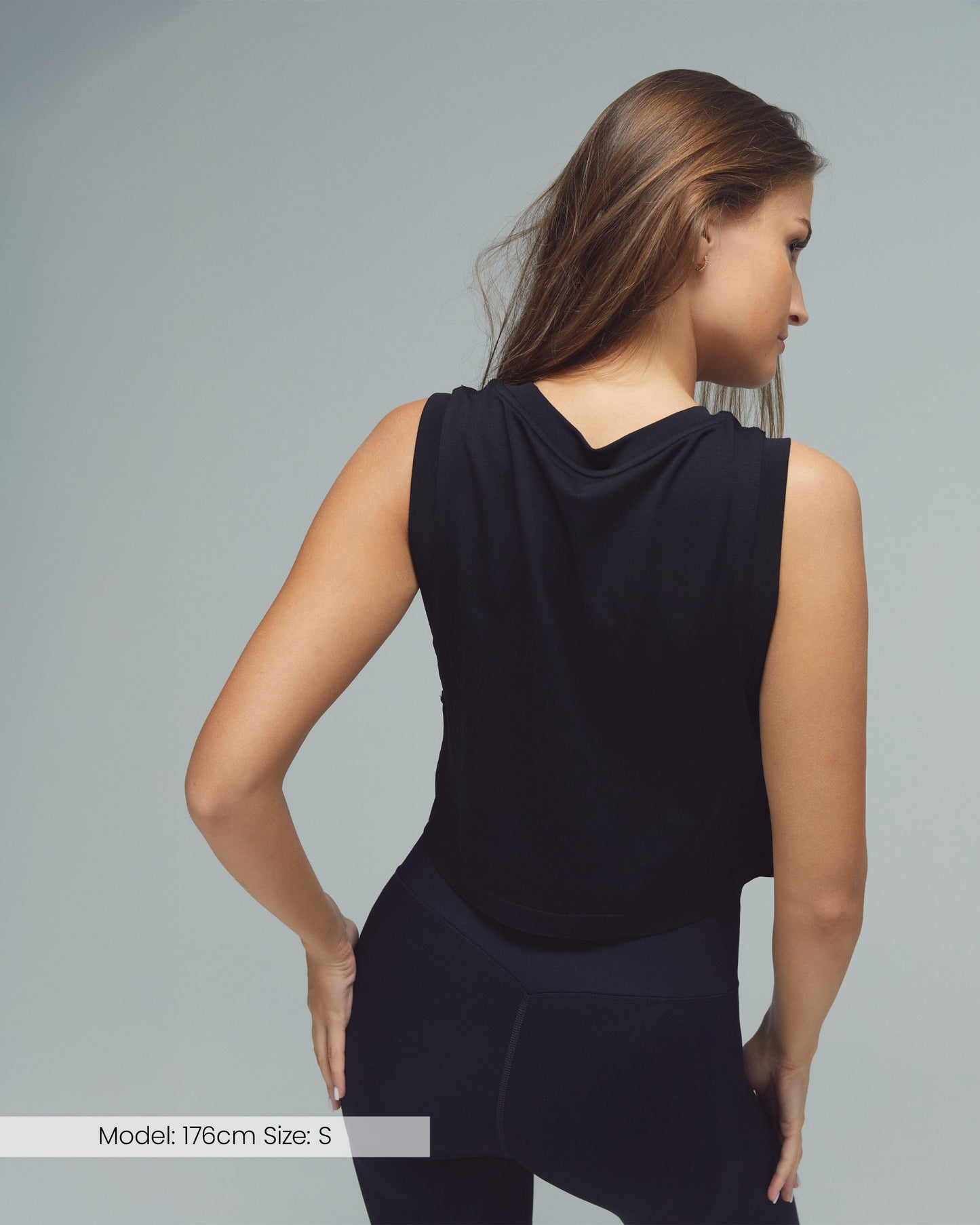 Model trägt das FLXFLOW Sport-Top von DRILLS in Schwarz