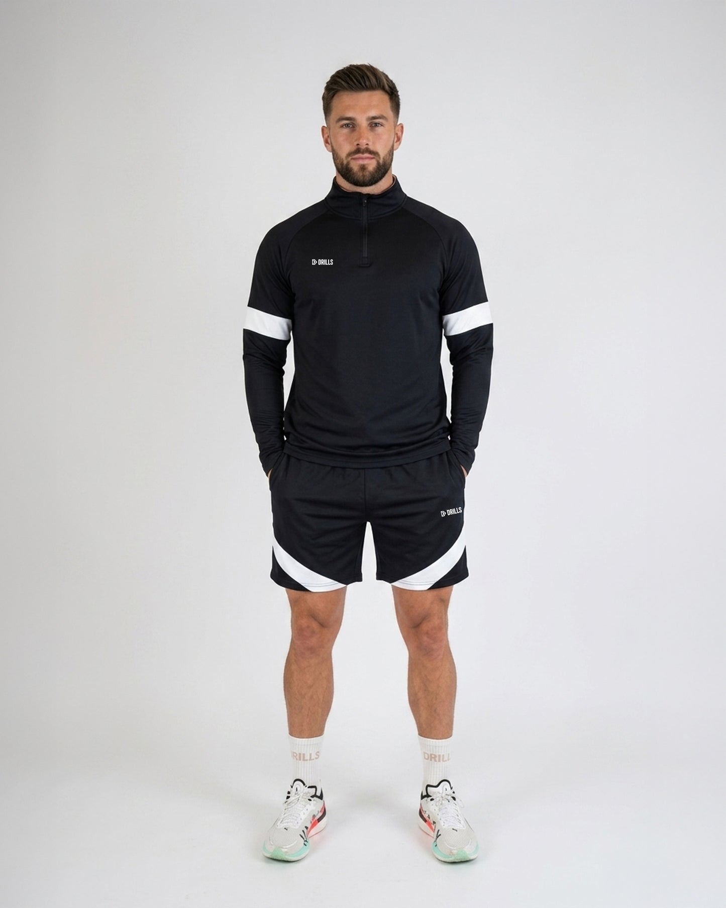 Model trägt die HYPE Track Shorts von DRILLS in schwarz