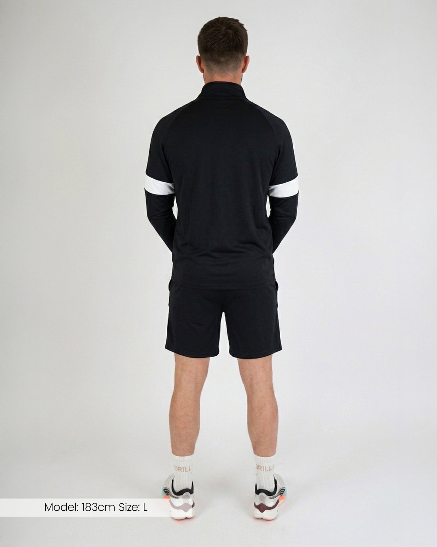 Model trägt die HYPE Track Shorts von DRILLS in schwarz