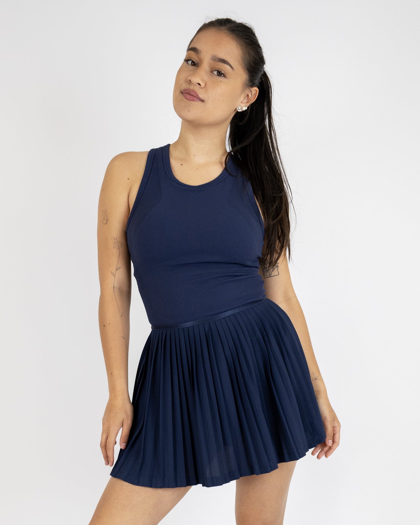 Model trägt das Tennisdress von DRILLS der Kollektion RACQUET in Navy Blau