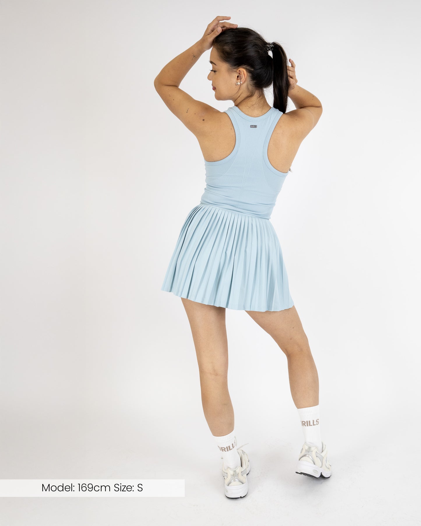 Model trägt das Tennisdress von DRILLS der Kollektion RACQUET in hellblau