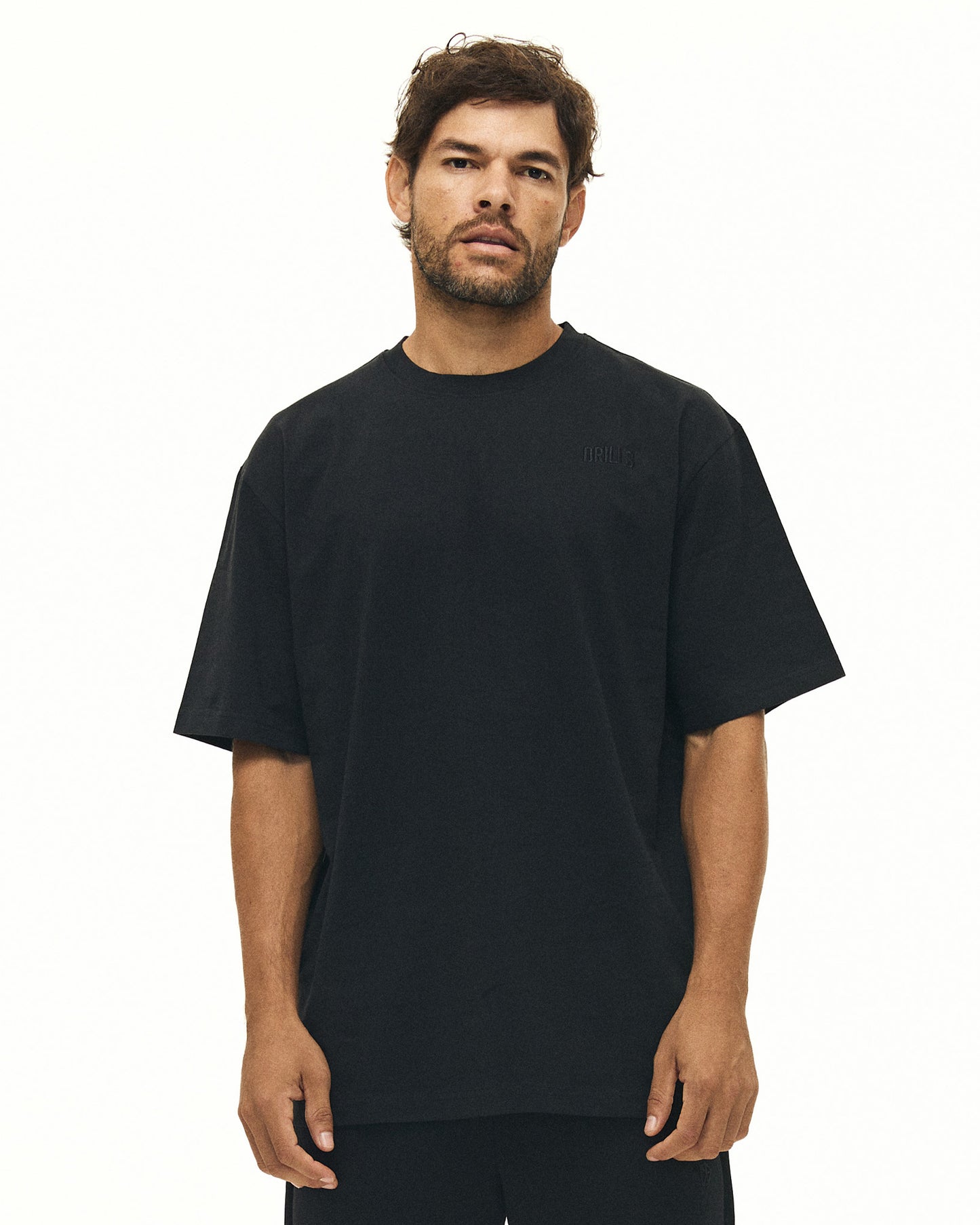 Model trägt das RECREATION Core T-Shirt aus Baumwolle von DRILLS in schwarz