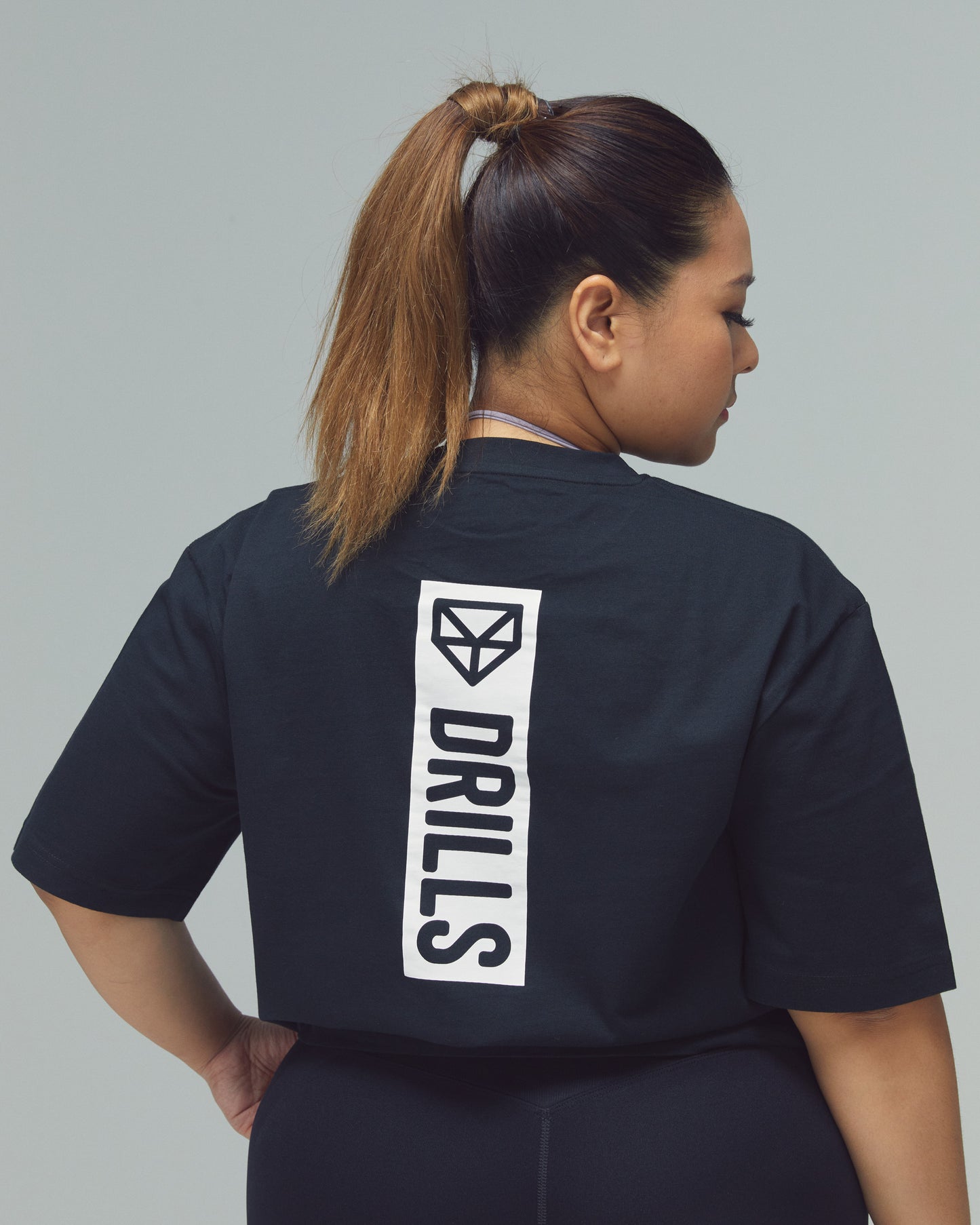 Model trägt das Vertical Graphic Tee von DRILLS in Black White