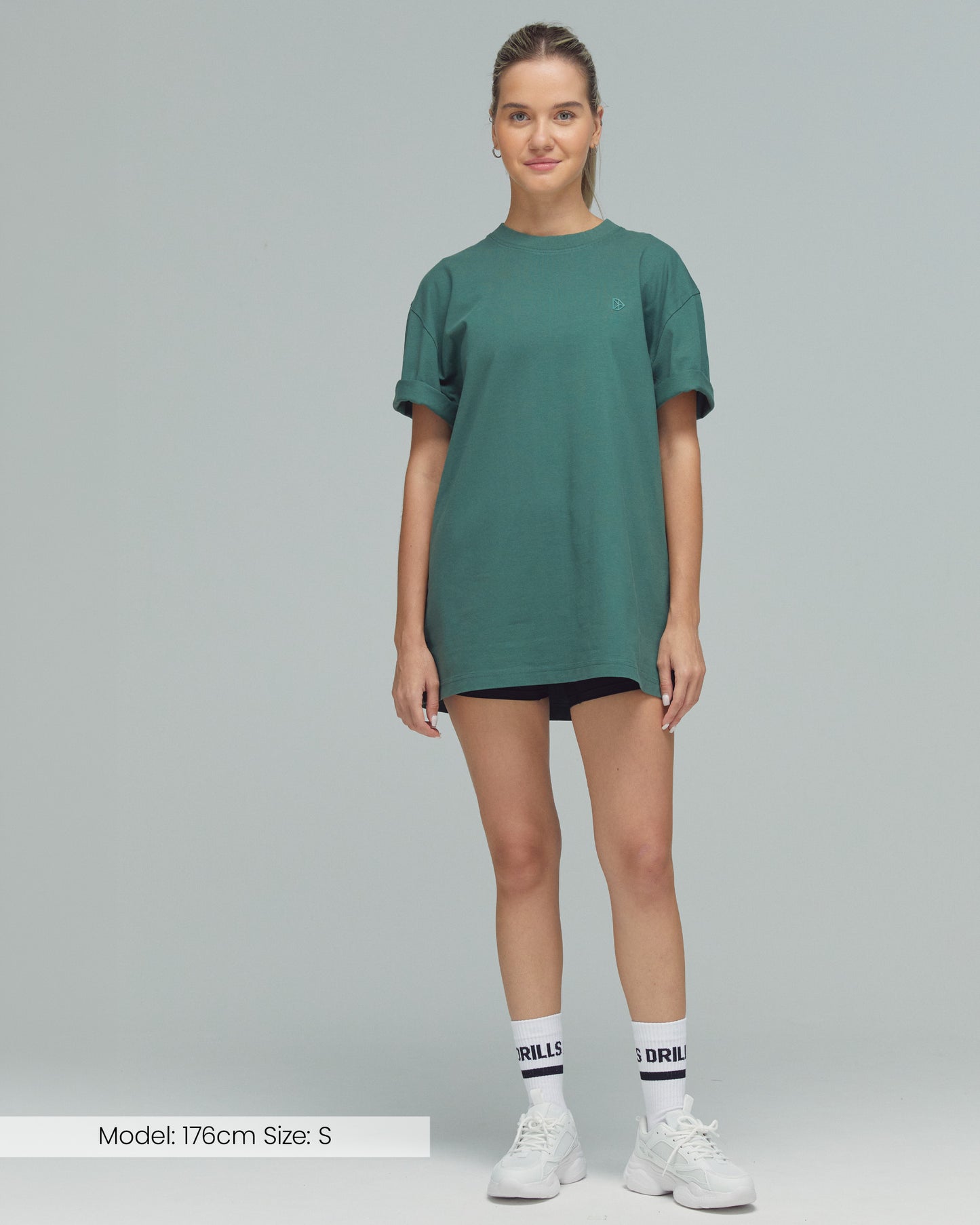 Model trägt das Vertical Graphic Tee von DRILLS in Dark Sage Green