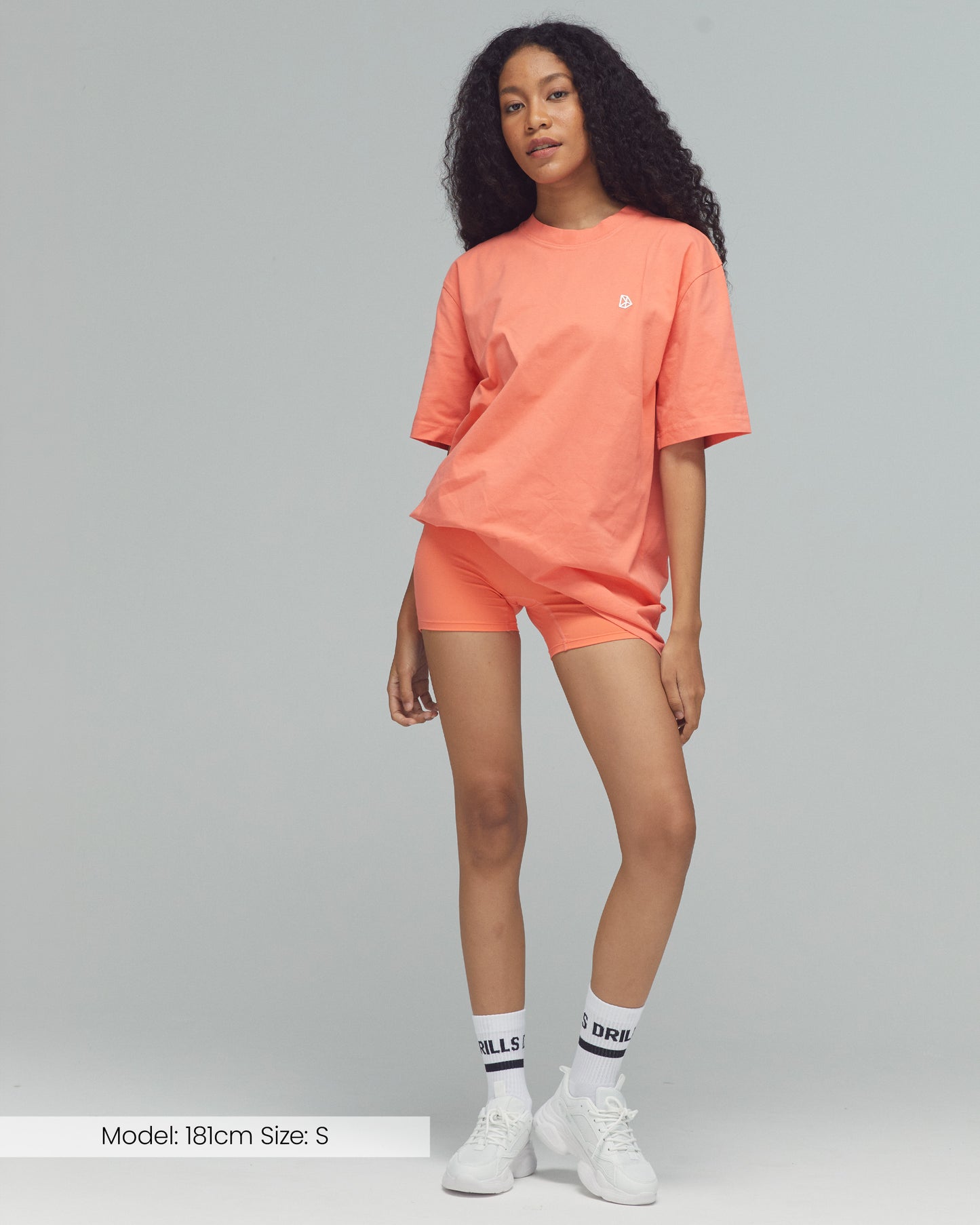Model trägt das Vertical Graphic Tee von DRILLS in sunset glow