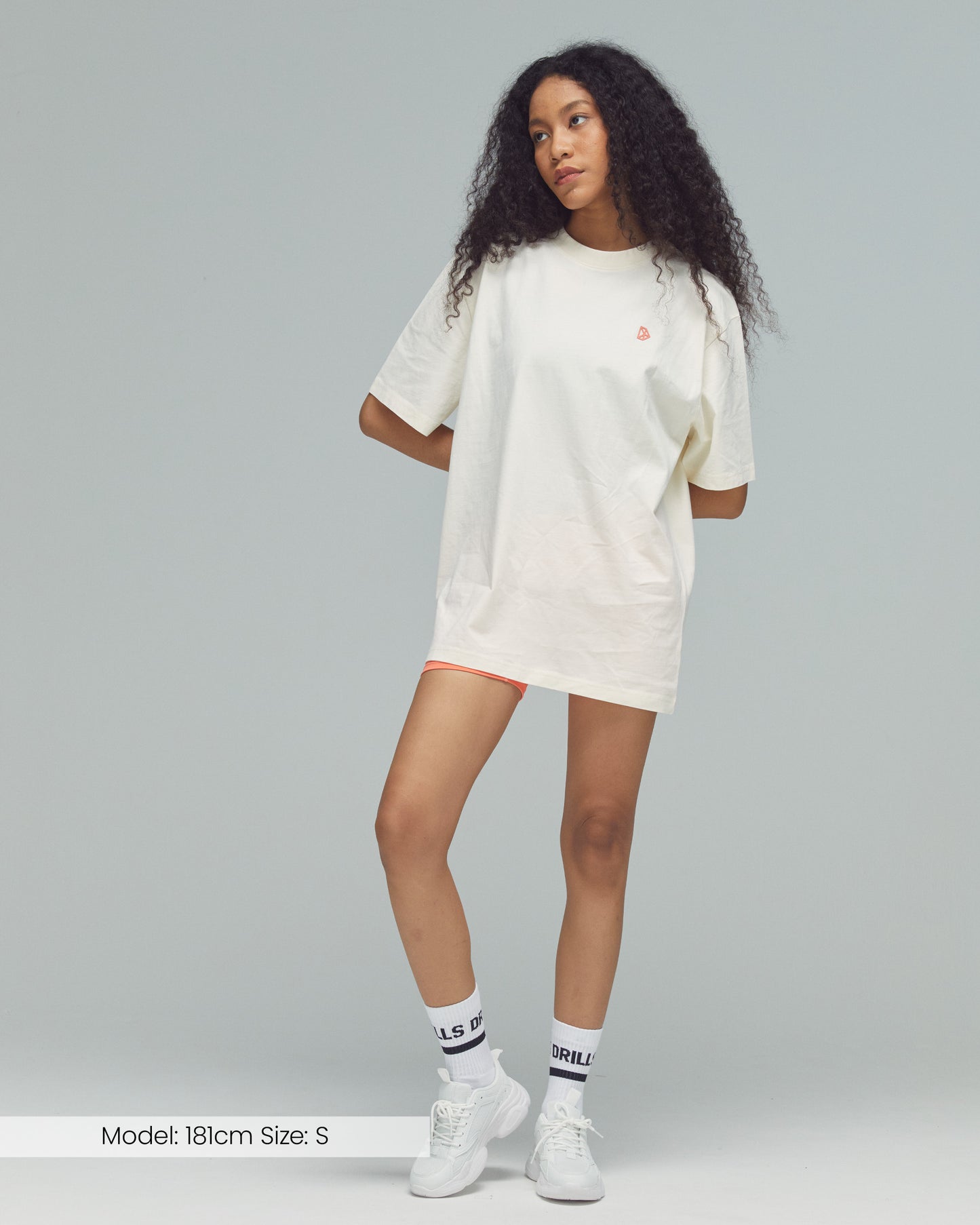 Model trägt das Vertical Graphic Tee von DRILLS in weiß - sunset glow