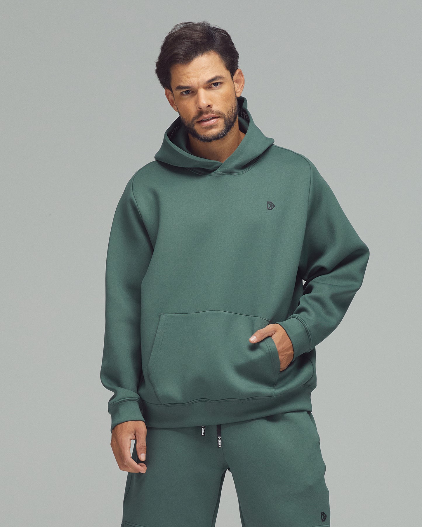 Model trägt den Scuba Hoodie von DRILLS in Dark Sage Green