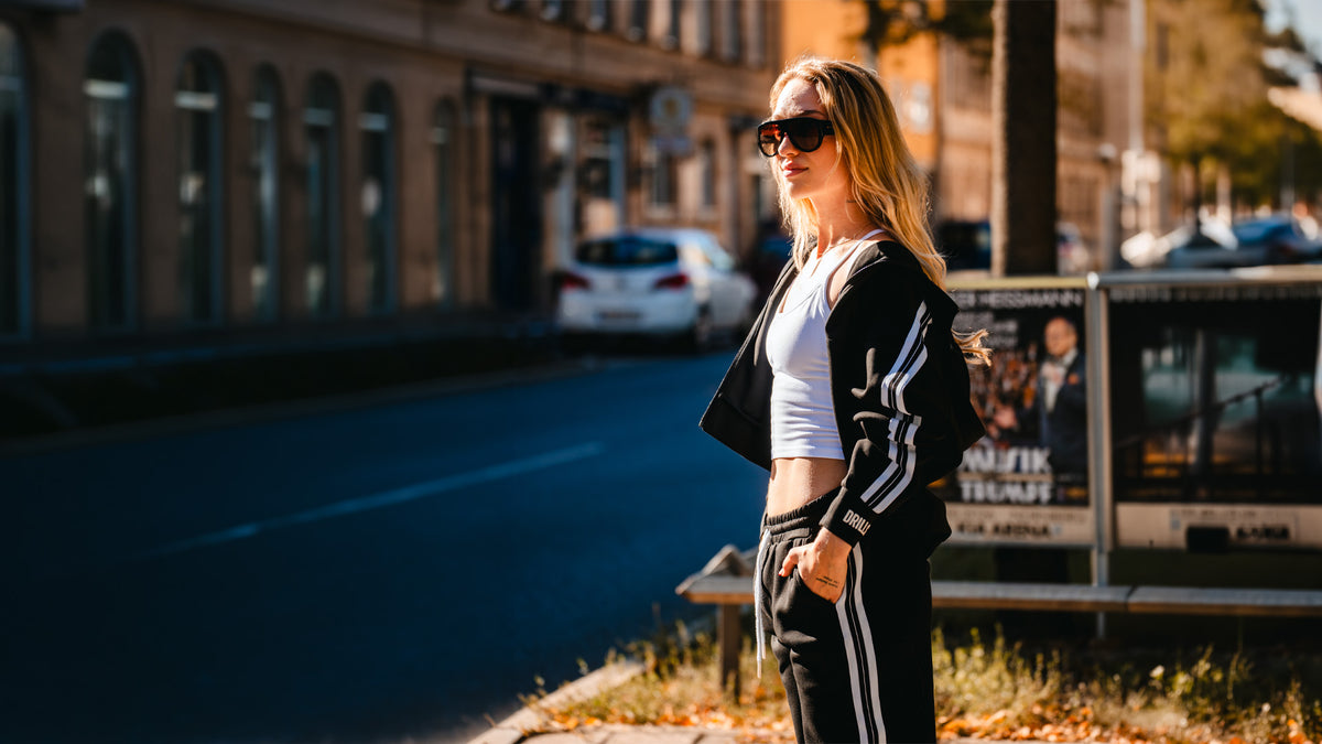 Model trägt den DRILLS Track Suit in schwarz