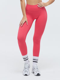 Model trägt die VIVID Scrunch Leggings von DRILLS in Raspberry