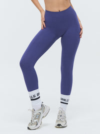 Model trägt die VIVID Scrunch Leggings von DRILLS in Skipper Blue