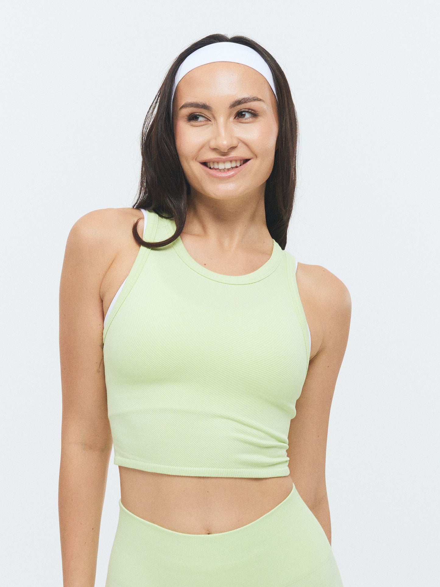 Model trägt das VIVID Rib Tank Top von DRILLS in butterfly grün