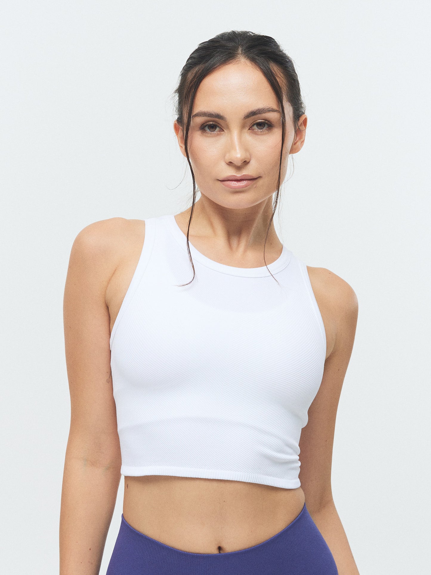 Model trägt das VIVID Rib Tank Top von DRILLS in weiß