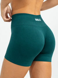 Model trägt die VIVID Scruch Shorts in Teal Blue von DRILLS