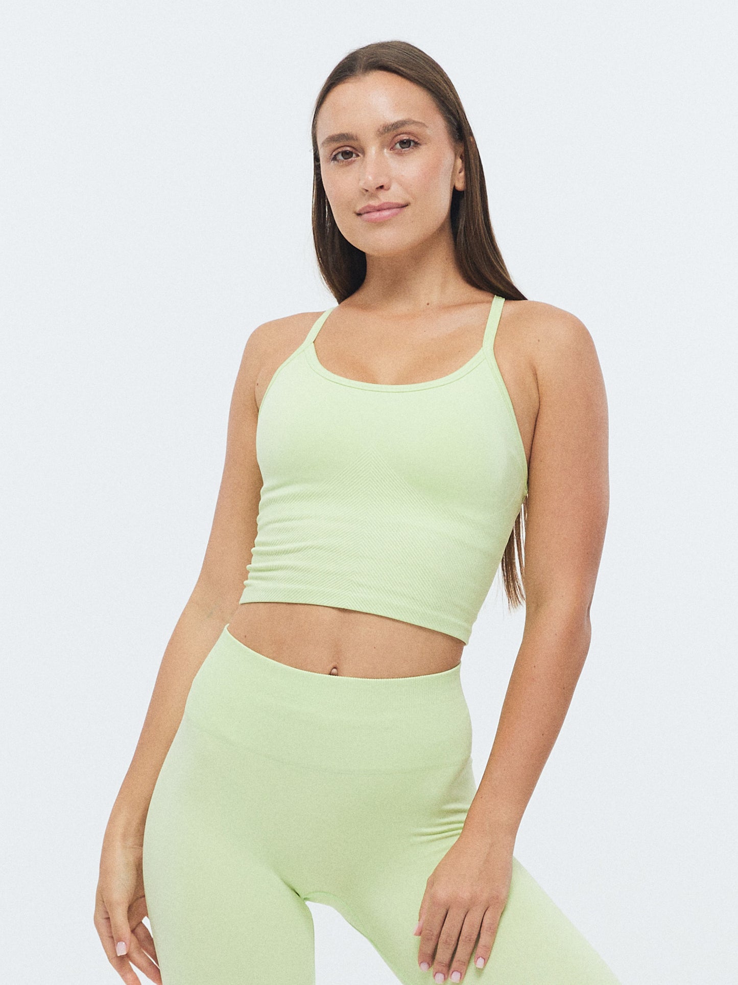 Model trägt das VIVID Sport Top in Butterfly grün von DRILLS