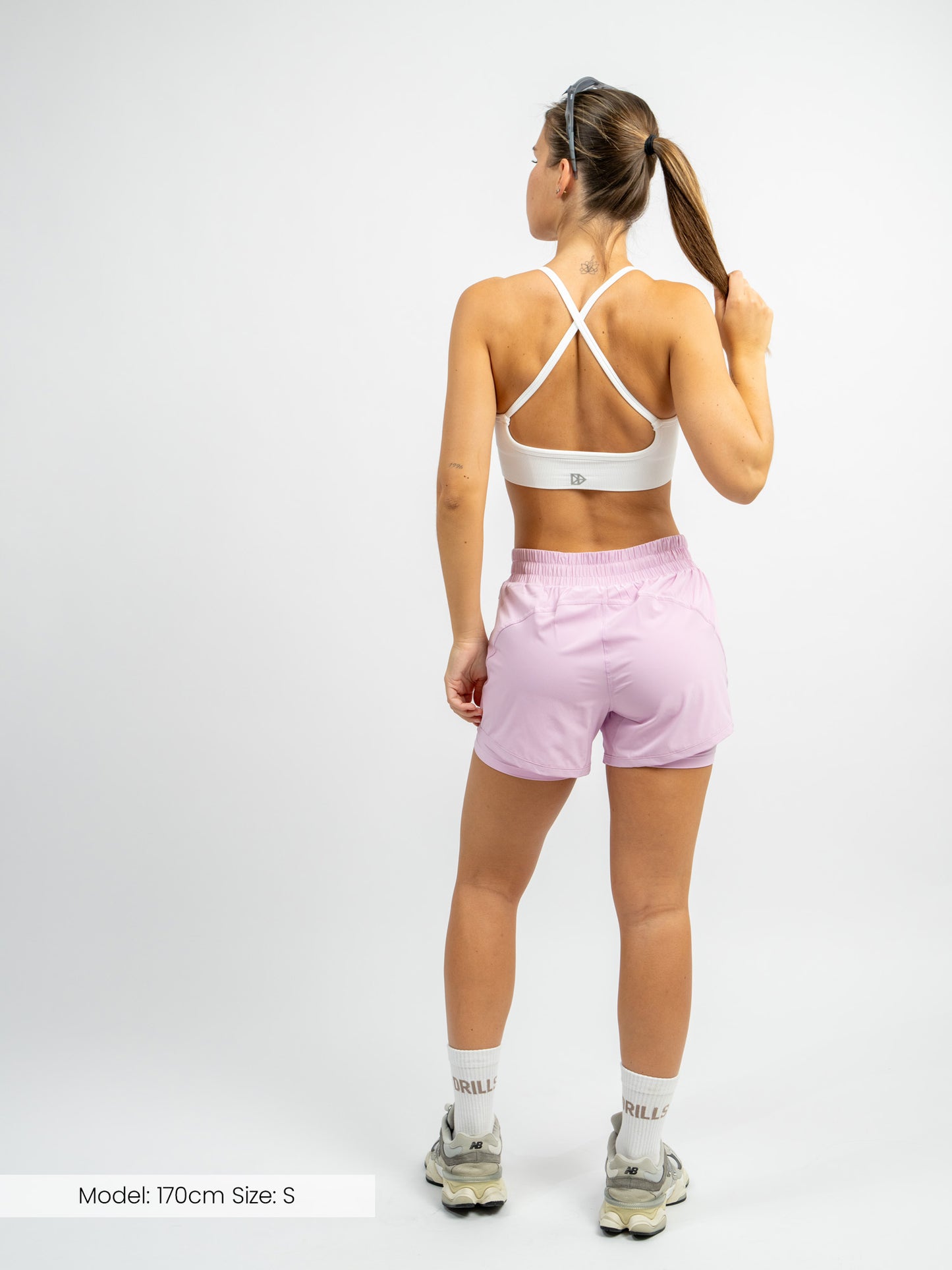 Model trägt die XFUNCTION 2-in-1 Laufhose von DRILLS in pink