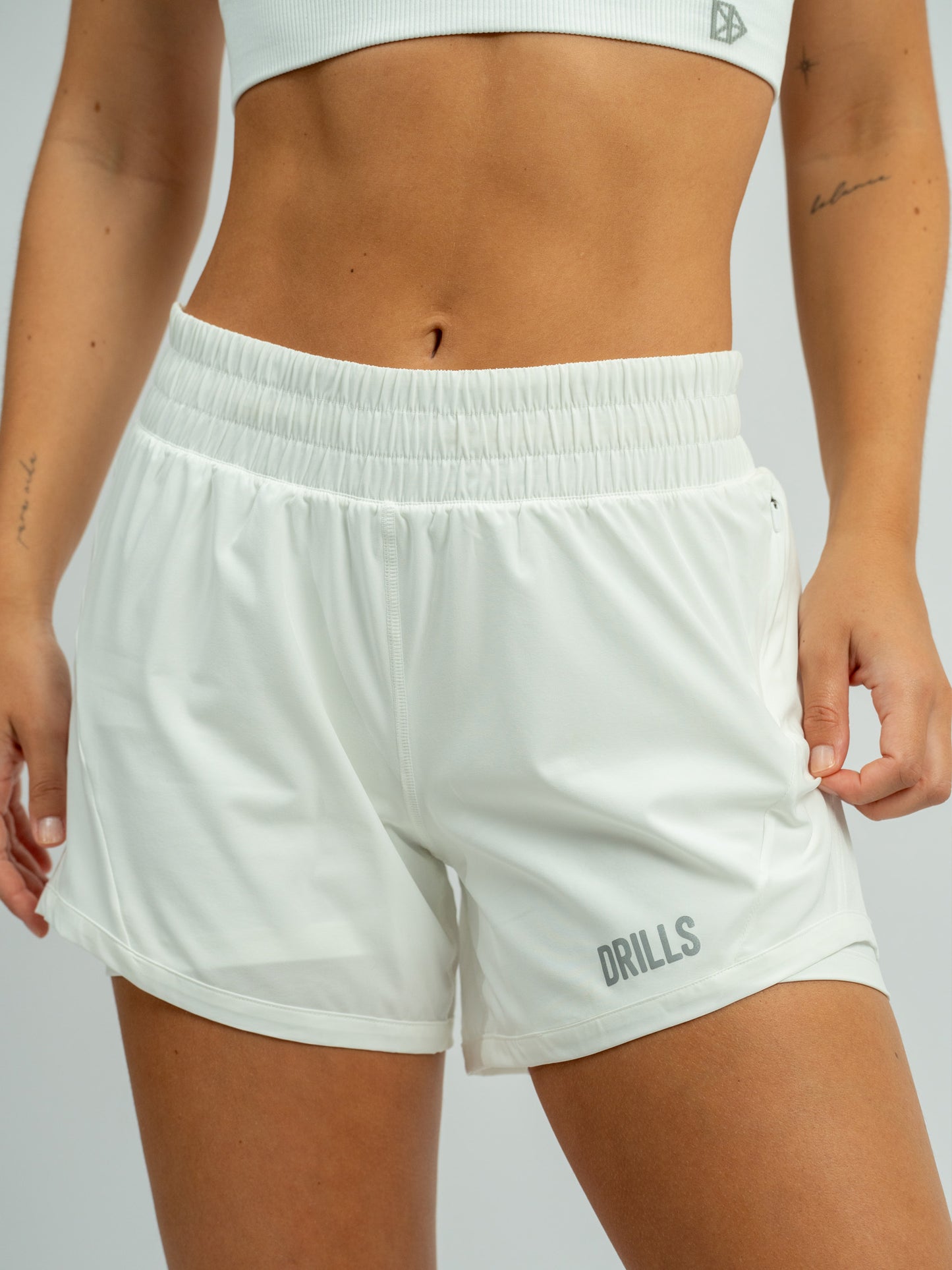Model trägt die XFUNCTION 2-in-1 Laufhose von DRILLS in white