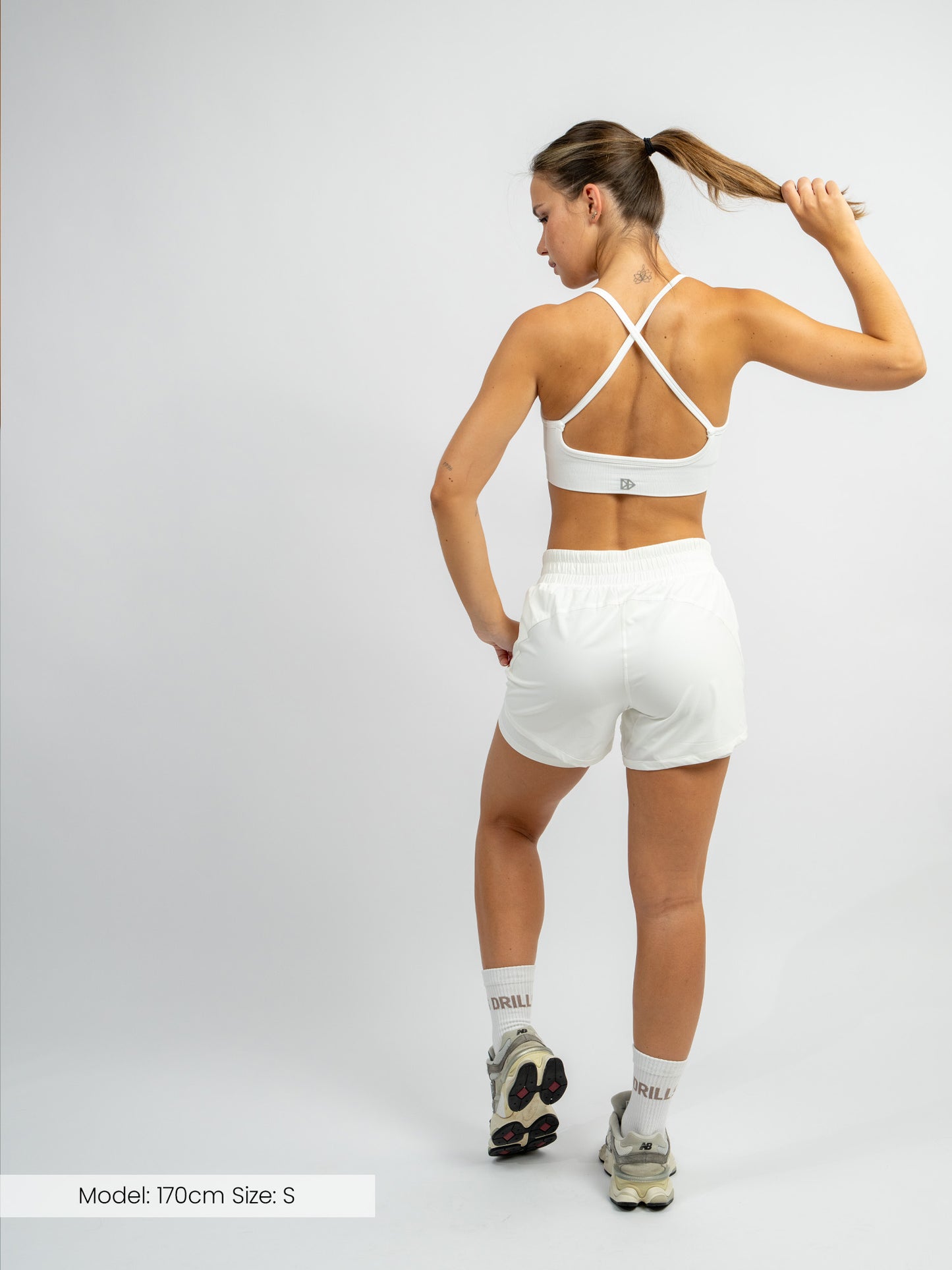 Model trägt die XFUNCTION 2-in-1 Laufhose von DRILLS in white