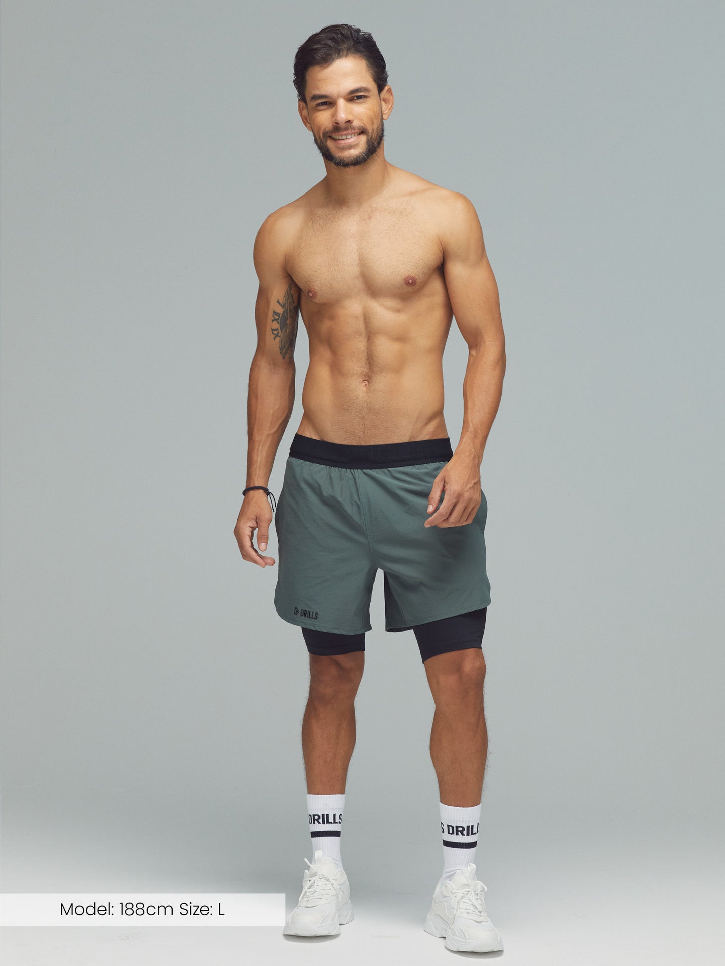 Model trägt die 2-in-1 Hose von DRILLS in Dark Sage Green