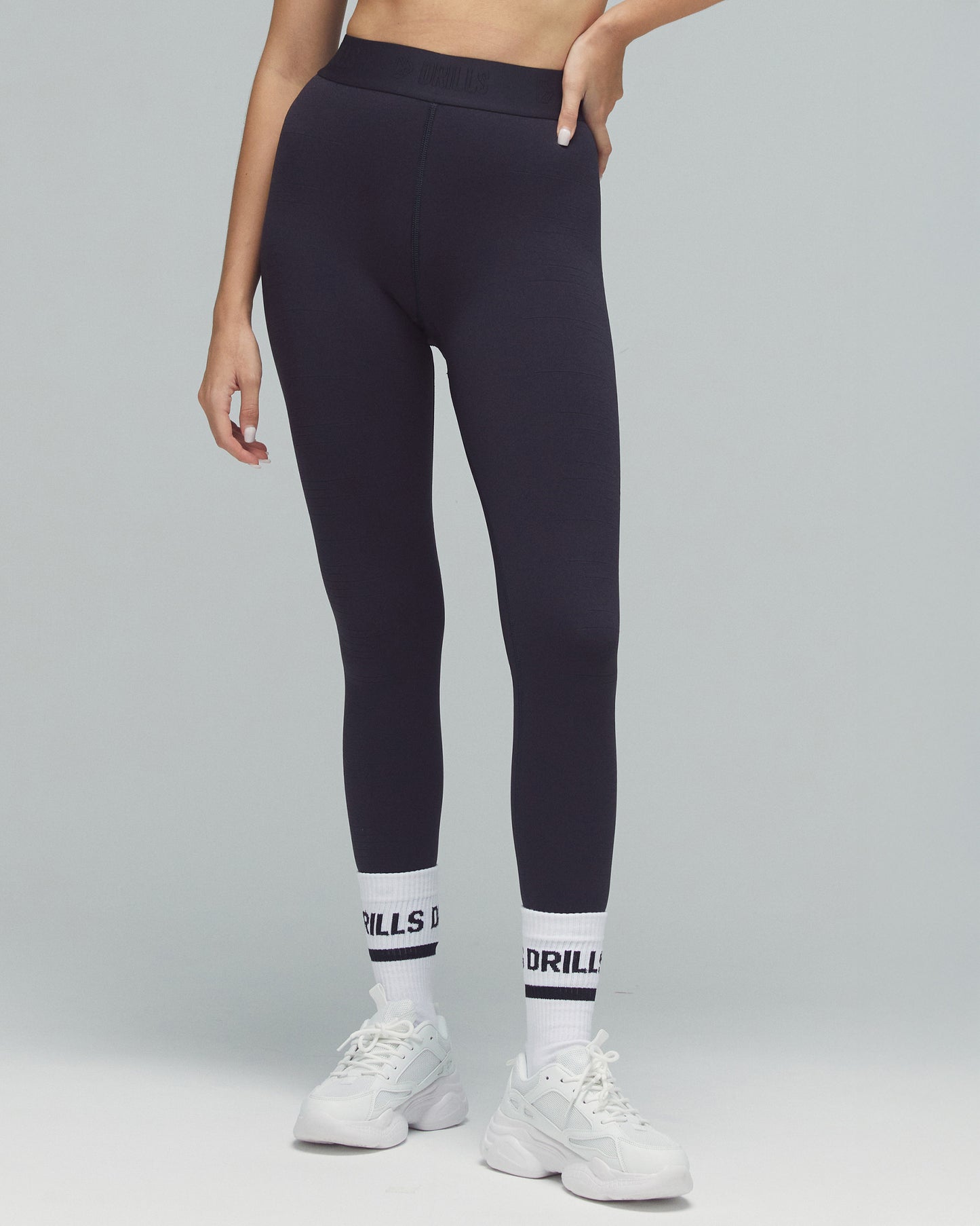 Model trägt die Tape Leggings von DRILLS der Kollektion XFUNCTION in schwarz
